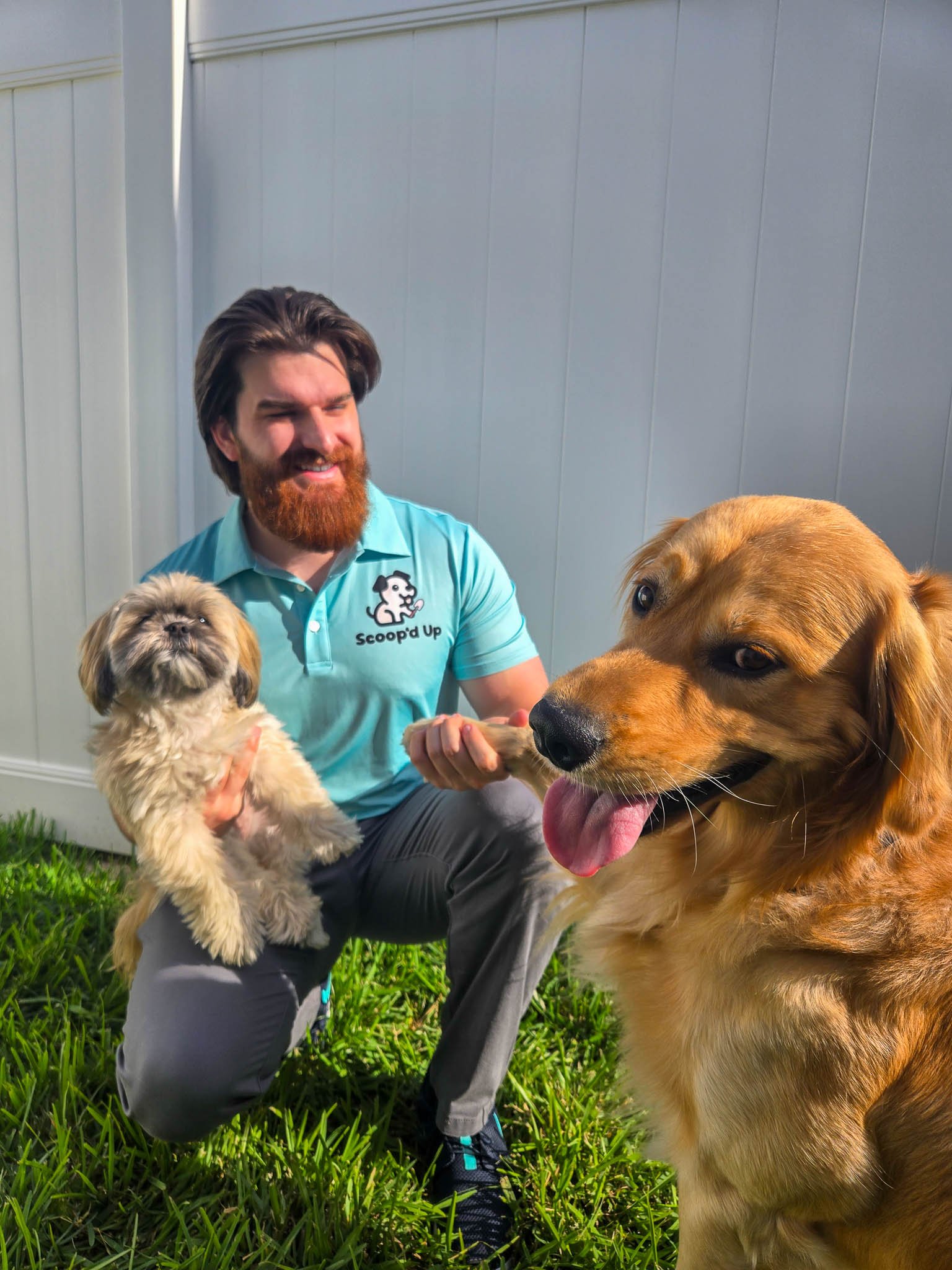 Scoopd Up Employee holding shih tzu and holding golden retriever paw