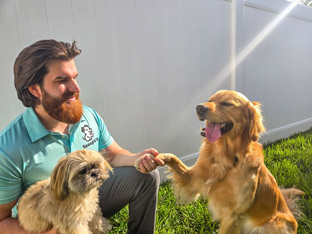 Scoopd Up Employee holding golden retriever paw